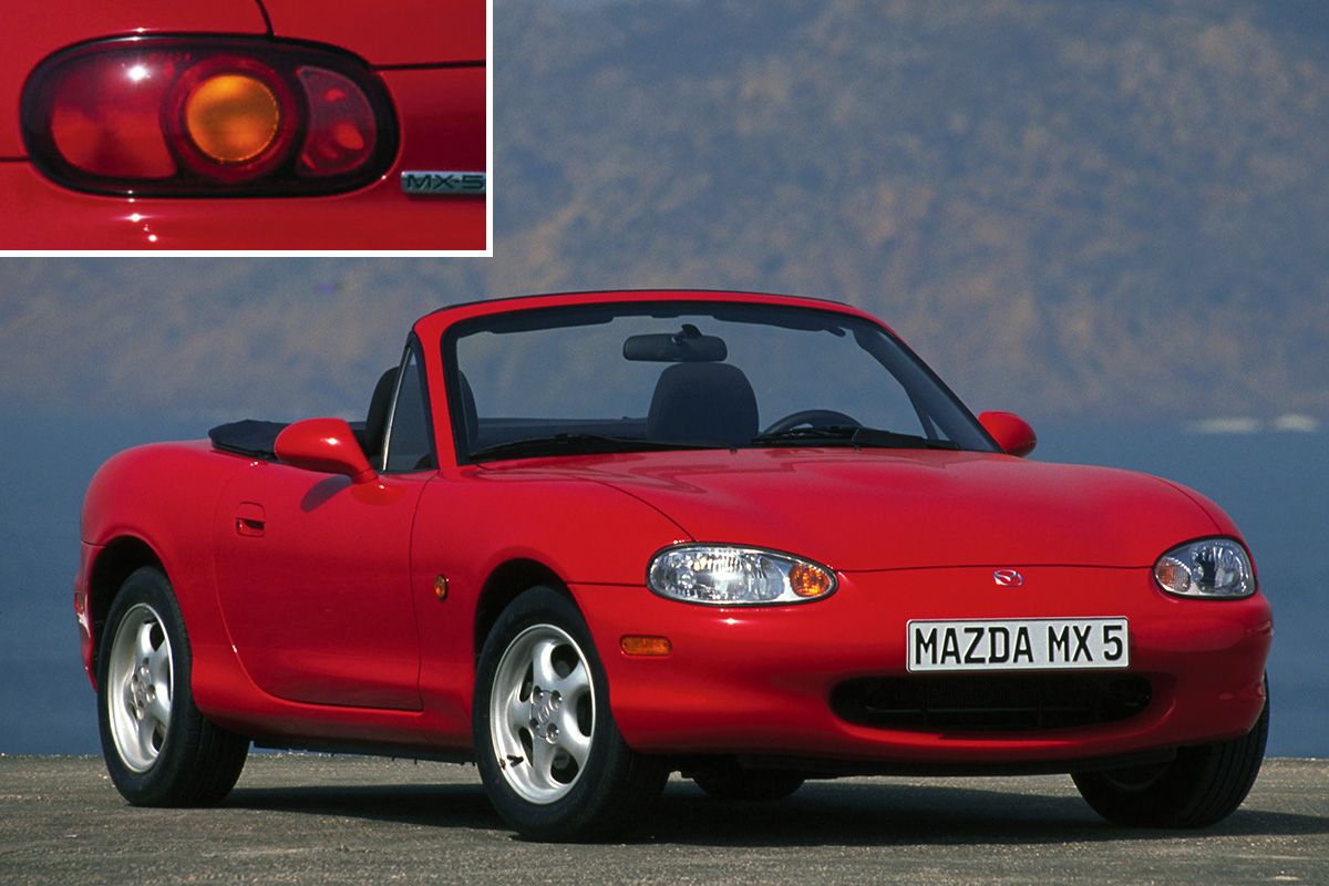 Una Mazda MX-5 NB rossa dove si nota la forma del paraurti anteriore e il fanale posteriore