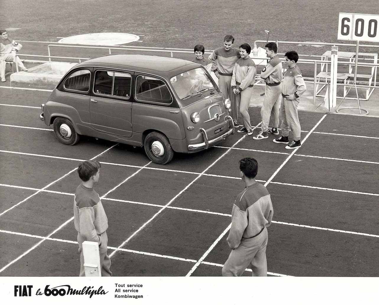 Squadra di atletica intenta ad ammirare una Fiat 600 Multipla
