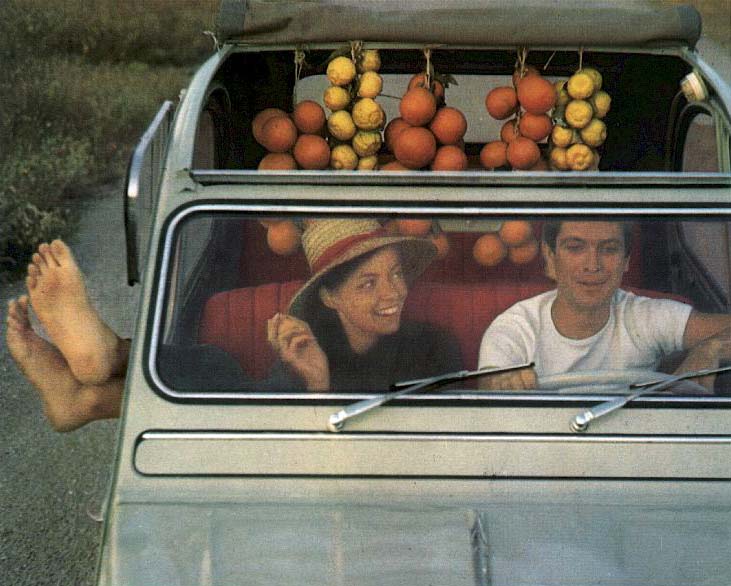 immagine tratta da brochure che ritrae una coppia francese a bordo della piccola utilitaria con dentro i prodotti della terra